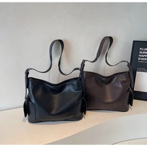 Detail view of large PU leather tote bags in black and dark brown with side pocket