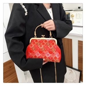 Detail of red Chinese style embroidery handbag with golden metal frame and top handle