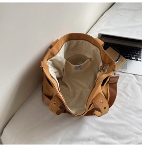 Detail view of khaki canvas tote bag interior with zipper pocket and brand label