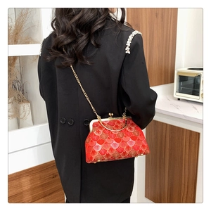 Detail of red Chinese style embroidery bag with golden chain and retro metal clasp