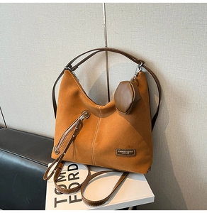 Close-up of brown suede hobo tote bag featuring a leather patch and round coin purse