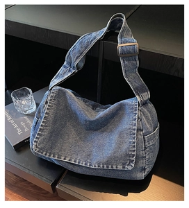 Dettaglio della borsa a tracolla in denim blu lavato con tracolla regolabile in vetrina