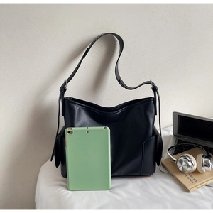 Detailed view of spacious black tote bag showing side pocket and tablet fit capacity