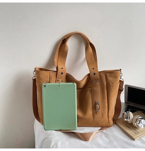 Brown tote bag with large capacity showing a green tablet inside for scale