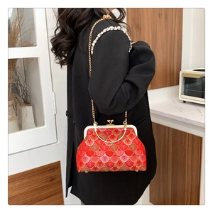 Detail of red vintage embroidery handbag with golden clasp and pearl handle