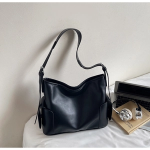 Close-up of black PU leather shoulder bag with spacious side pocket and silver hardware
