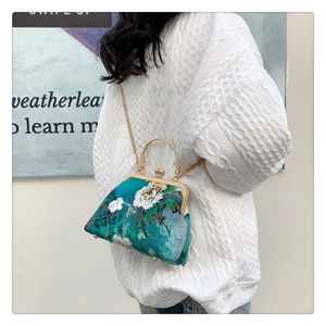 Detail of teal floral satin cheongsam handbag with gold frame and chain strap