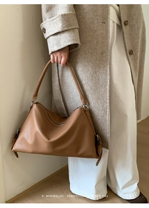 Close-up of minimalist brown tote bag with premium lychee texture and soft leather finish