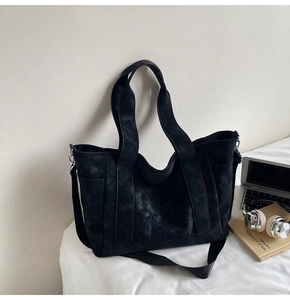 Detail view of large dark grey canvas tote bag with laptop and headphones for commuting