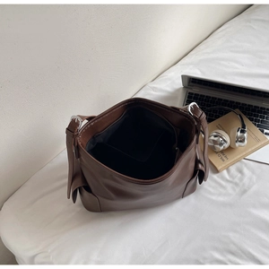 Detail view of large brown PU leather tote bag interior and side pocket construction