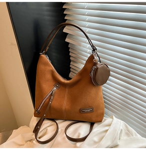 Caramel suede tote bag detail featuring front zipper pocket and round coin purse charm