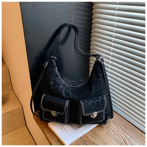 Close-up of vintage black leopard print shoulder bag with silver locks and white stitching