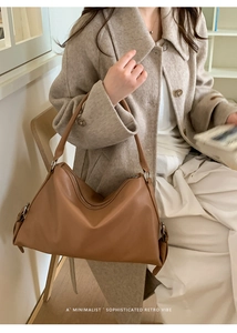 Detail view of the brown leather tote bag with side buckle and zipper closure