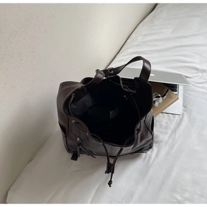 Close-up of brown vintage tote bag showing interior storage, drawstring and lining tag