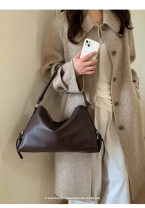 Detail showing deep brown lychee grain leather texture on minimalist shoulder bag