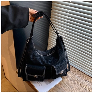 Detail of black leopard print hobo bag with contrast stitching and silver metal buckles