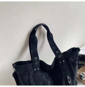 Detail view of black canvas tote bag with silver rivets and textured finish for work
