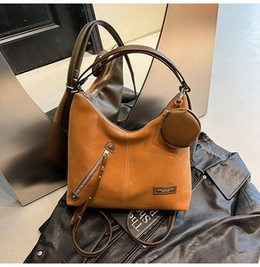 Detail of vintage brown suede tote bag with slanted zipper and mini coin purse attachment