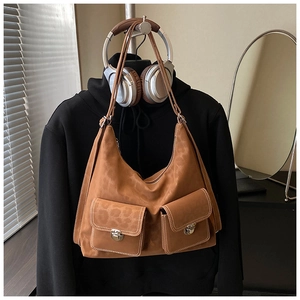 Detail of suede hobo shoulder bag with leopard print pattern and metal buckle pockets