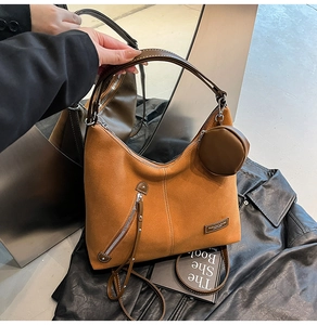 Detail of caramel suede hobo bag with fringe zipper, mini pouch and brand label