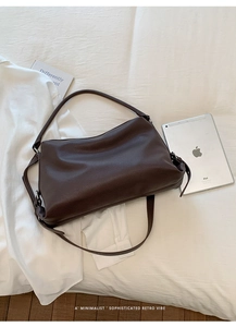 Close-up of dark brown lychee texture leather shoulder bag in a minimalist retro style