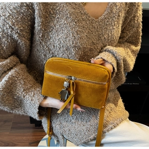 Vue détaillée du sac bandoulière vintage en daim jaune gingembre avec pendentif robot