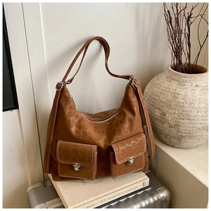 Detail of leopard print faux suede shoulder bag with dual buckle pockets on luggage