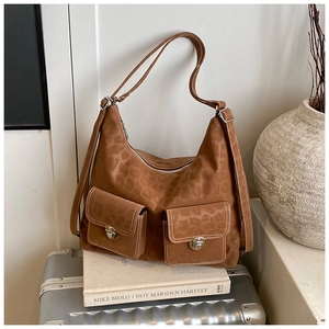 Detailed view of brown leopard print suede tote with silver hardware and white stitching