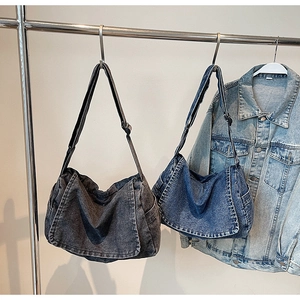 Detailed view of vintage washed denim bags in dark grey and classic blue with wide straps