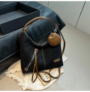 Detail of black matte tote with brown leather handles and detachable small coin purse