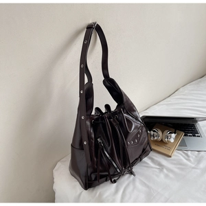Close-up of vintage brown bucket bag with silver studs and zipper pocket detail