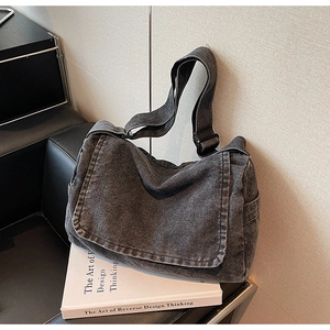 Dettaglio macro del denim lavato e della fibbia in metallo nero della borsa a tracolla grande