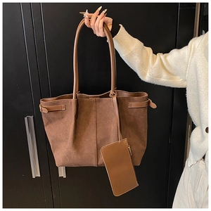 Détail d'un grand sac cabas en suédine marron avec petite pochette zippée et boucles en cuir