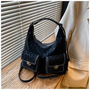 Close-up of black leopard texture tote bag with white contrast stitching and silver locks