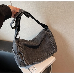Dettaglio della borsa a tracolla vintage in denim grigio scuro con cinturino regolabile