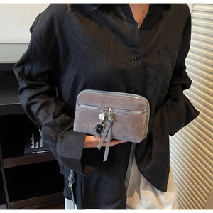 Vue détaillée du sac bandoulière gris givré avec pendentif robot et tirette en cuir longue