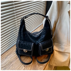 Detail shot of black leopard texture underarm bag with white contrast stitching and buckles