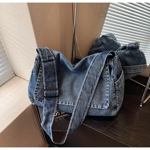 Dettaglio borsa a tracolla in denim blu con tracolla regolabile e tasca laterale