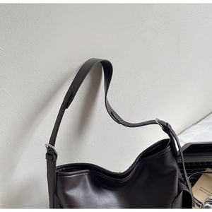 Detail of dark brown matte PU leather shoulder bag with adjustable silver buckle