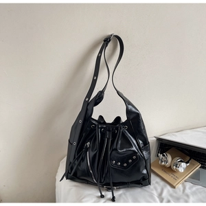 Detail of black motorcycle bucket bag featuring silver studs and zipper accents