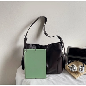 Detail view of large dark brown leather tote bag showing spacious capacity and side pocket