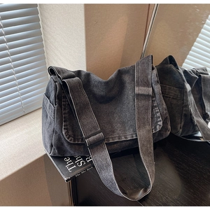 Dettaglio della borsa a tracolla vintage in denim grigio scuro con cinturino largo