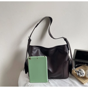 Detail view of deep brown large PU leather tote bag showing side pocket and shoulder strap