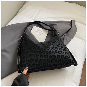 Detail view of black leopard print hobo bag with contrast stitching on leather strap
