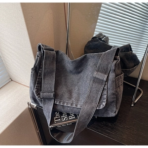 Dettaglio ravvicinato della borsa a tracolla in denim grigio con tracolla regolabile