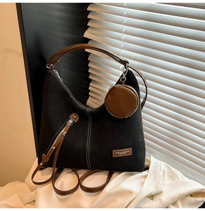 Detail of black suede tote bag with contrast stitching and mini round coin purse