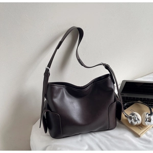Close-up of a large dark brown PU leather tote bag with adjustable strap and side pockets