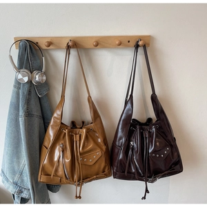 Macro shot of retro bucket bags in brown and chocolate colors with metallic rivet details
