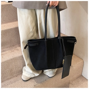Détail du sac cabas en daim noir avec boucles latérales et petite pochette assortie