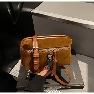 Close-up of vintage brown suede crossbody bag featuring a cute metal robot pendant